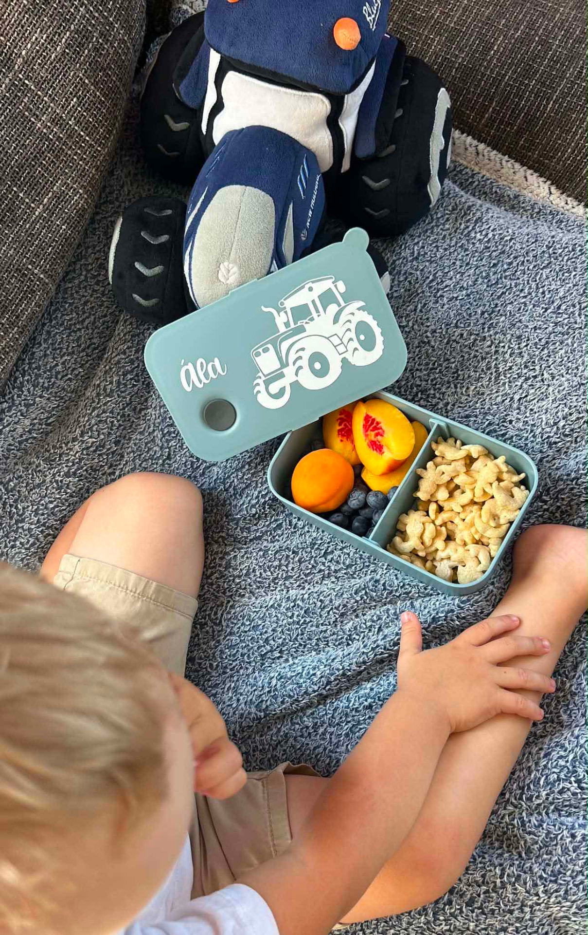 Tyrkysový svačinový box s traktorem a jménem Ála se svačinou